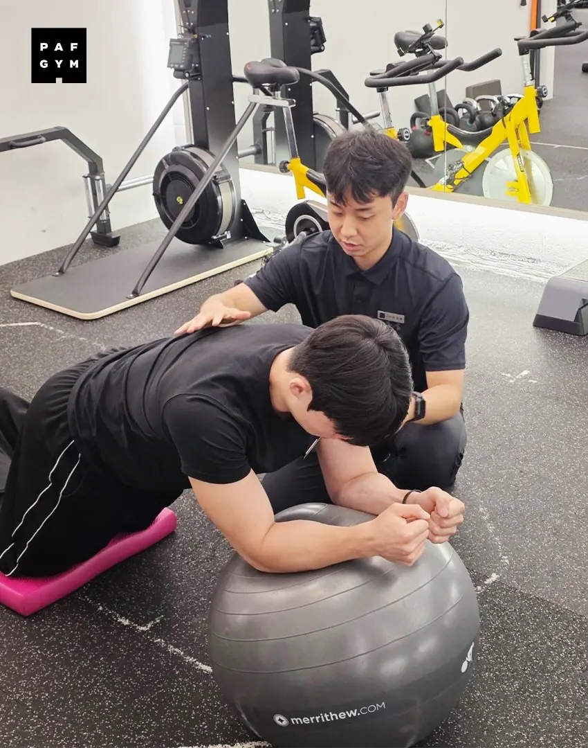 박진홍 트레이너 · 짐볼 위에서 코어 운동 자세를 잡아 주는 모습