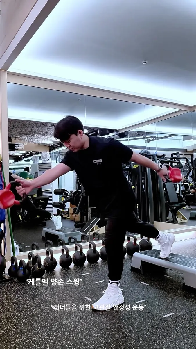 박우혁 트레이너 · 케틀벨을 든 한 발 운동을 시연하는 모습