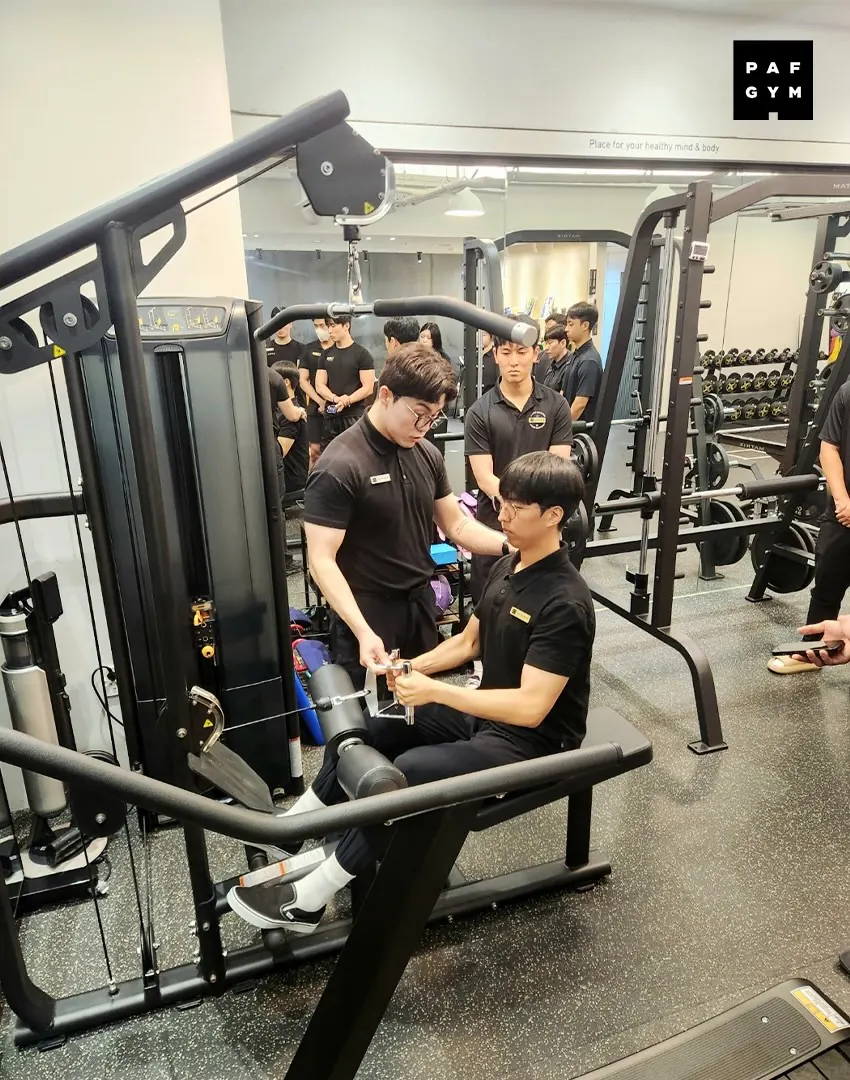 전상현 트레이너 · 교육생에게 머신 운동 자세를 지도하는 모습