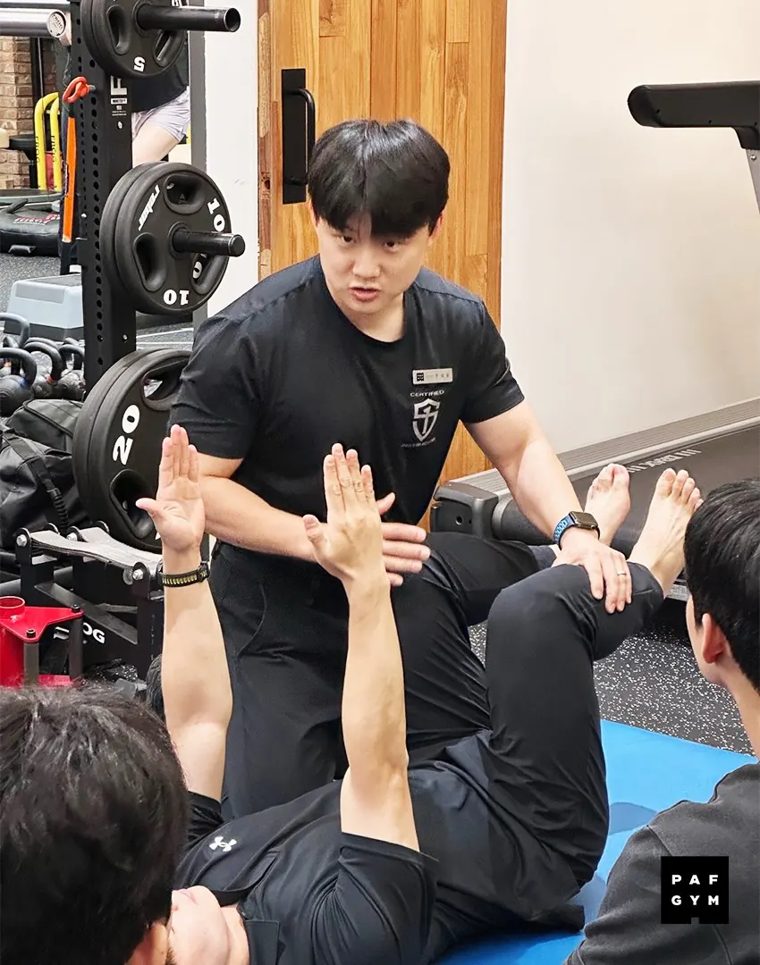 주성승 트레이너 · 교육생의 매트 운동 자세를 직접 잡아 주는 모습