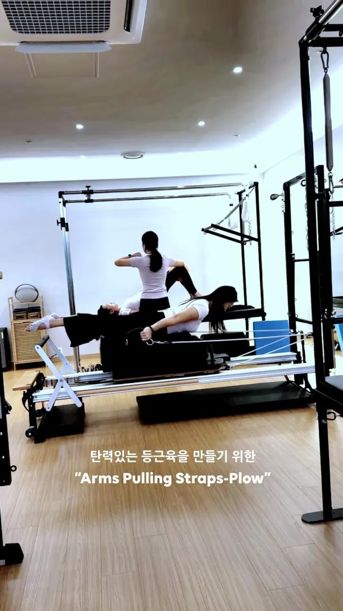 문시진 트레이너 · 리포머에서 스트랩을 당기는 등 운동을 시연하는 모습